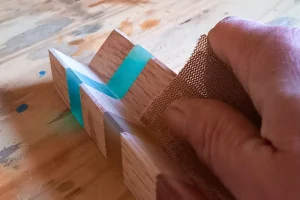 ponçage manuel d’un support de roulage dans l’atelier ZenRollCraft